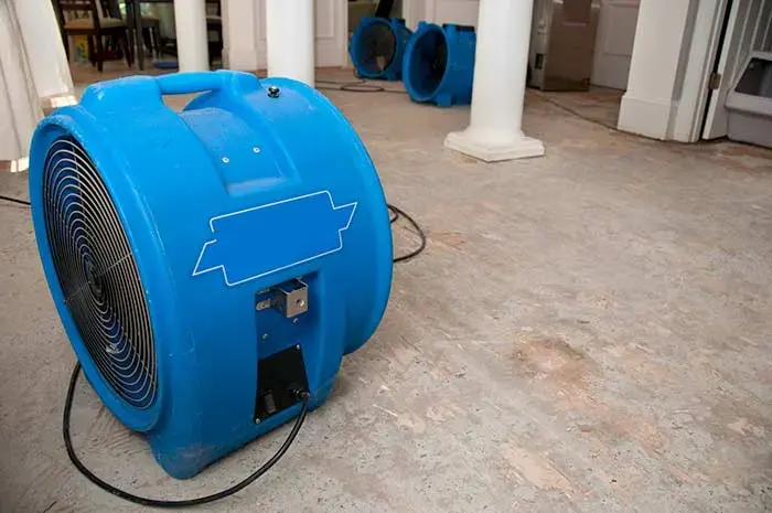 Large air mover drying a floor during a water damage dry-out in North Richland Hills