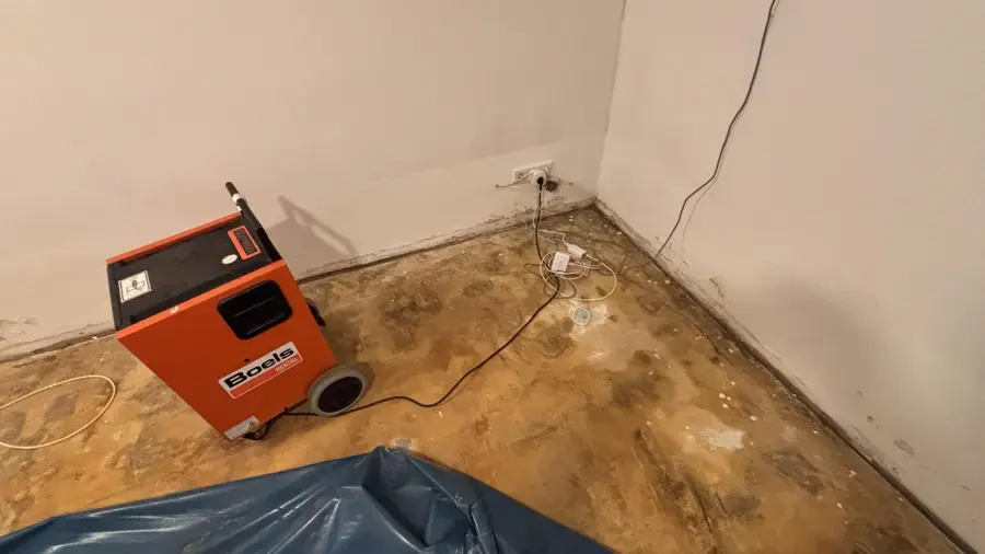 Dehumidifier drying a wet subfloor after flooring was removed